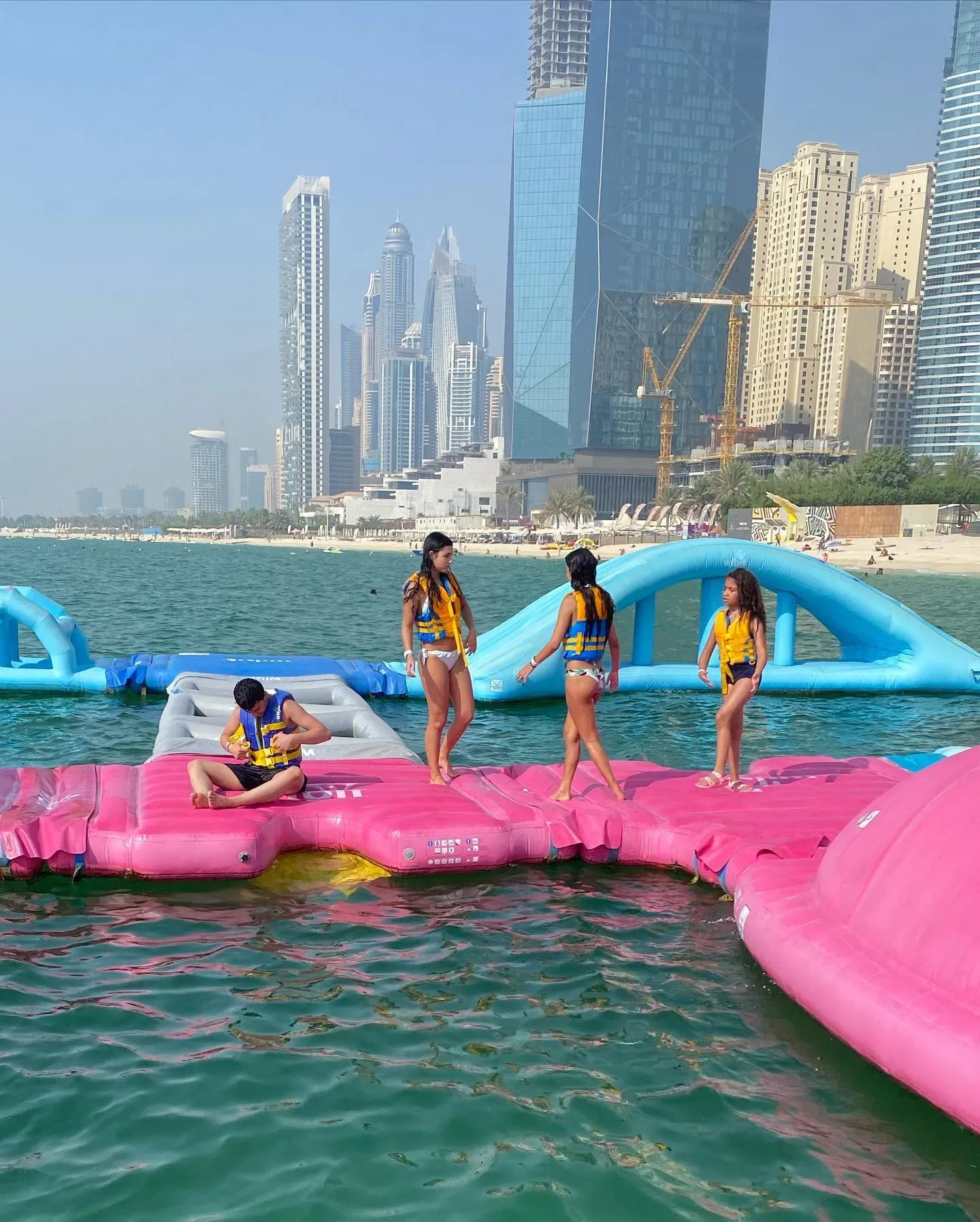 Aqua Fun Dubai water park with colorful inflatable obstacles and Dubai Marina skyline