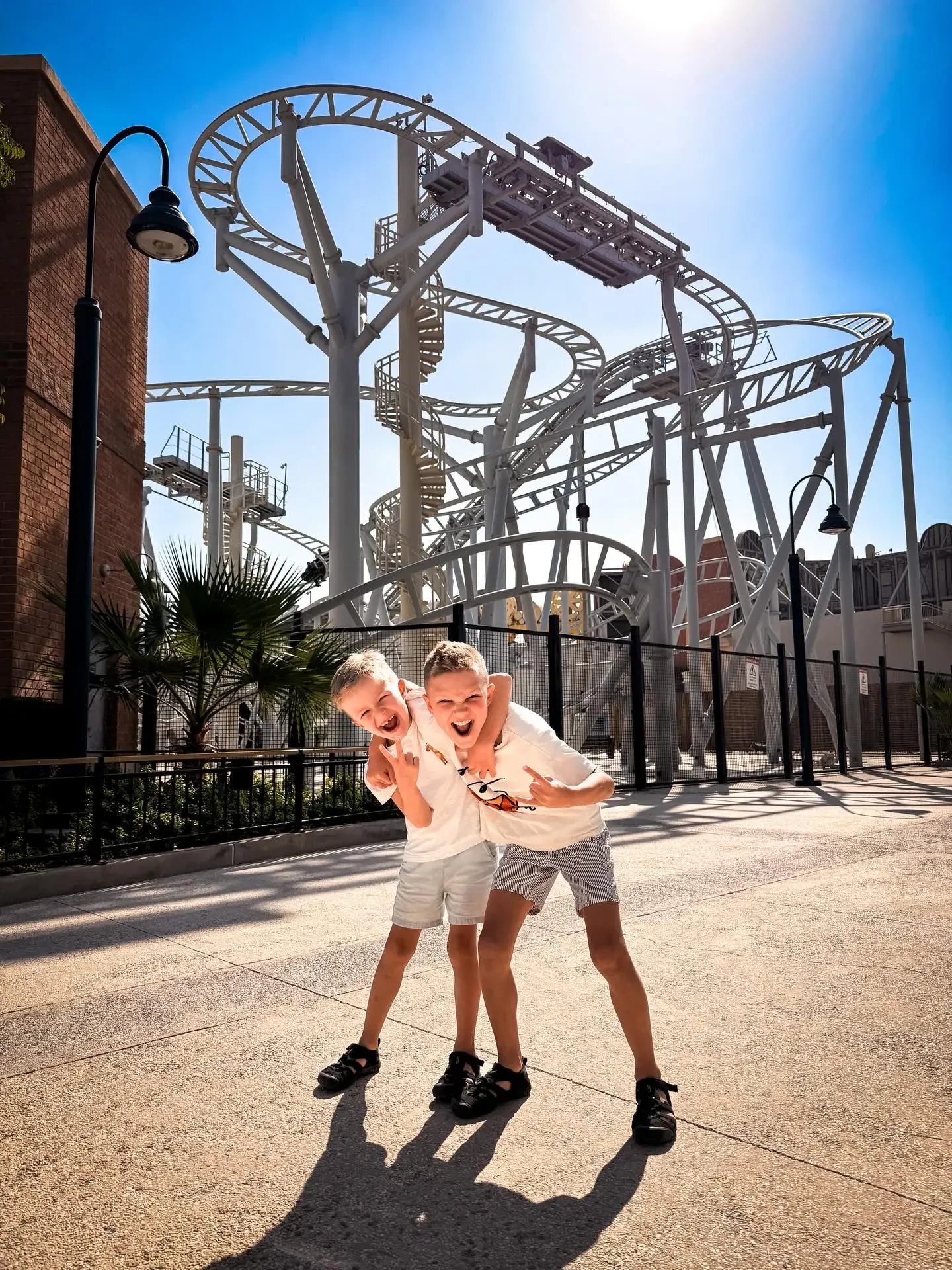 Children posing near roller coaster at Dubai Parks and Resorts