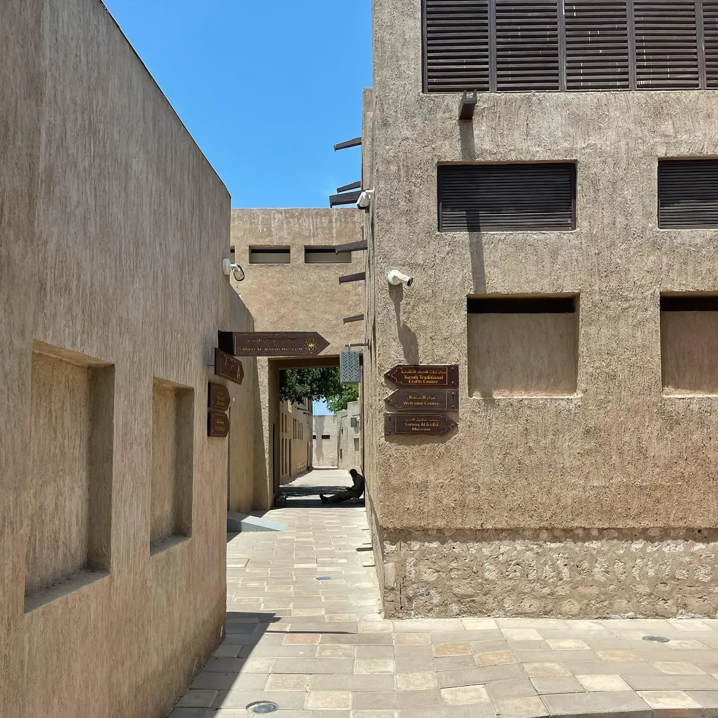 Traditional museum pathway with directional signs for Heritage Village and Al Shindagha Museum exhibits