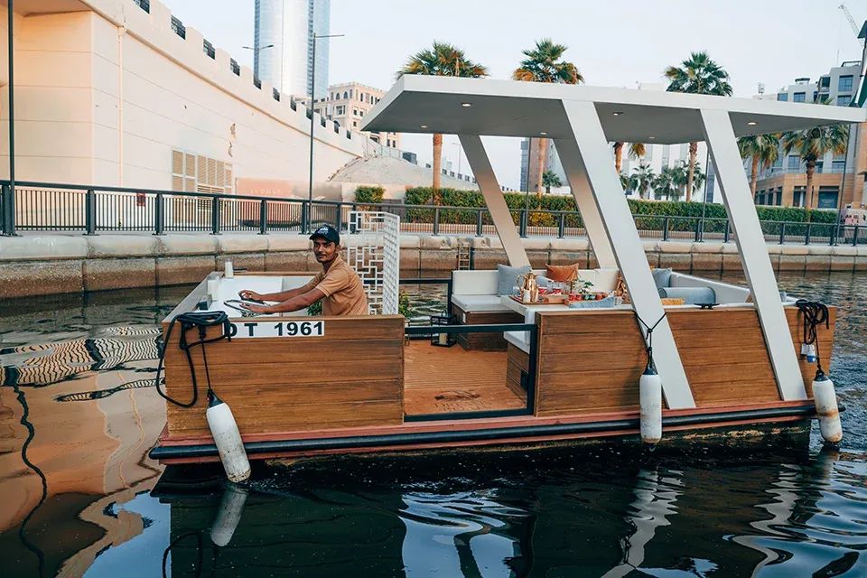 Dream Boats Floating Cafe wooden boat cruising on Dubai water with city skyline