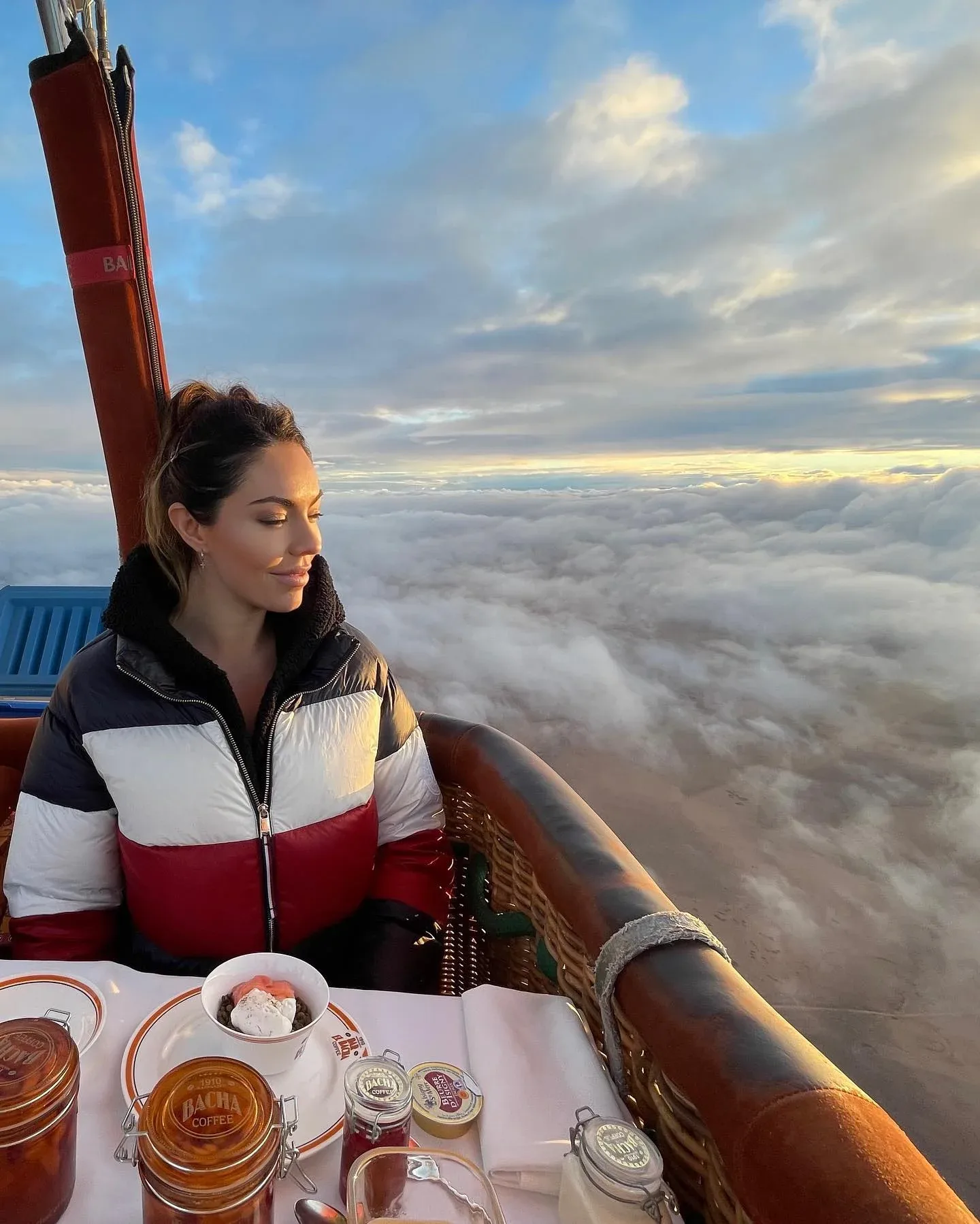 Woman enjoying breakfast during a hot air balloon flight over Dubai desert
