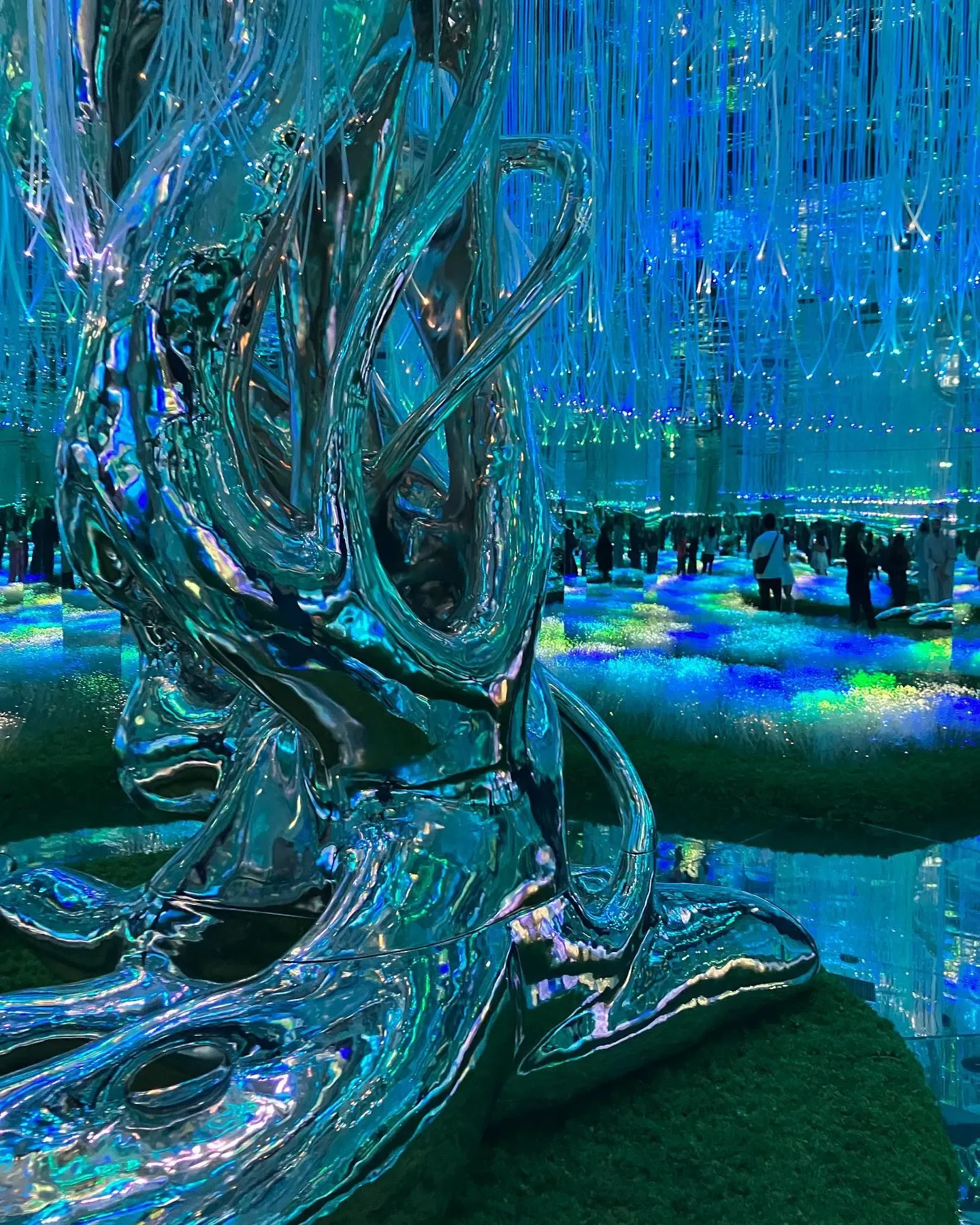 AYA Universe Dubai reflective tree sculpture surrounded by glowing blue and green immersive lights