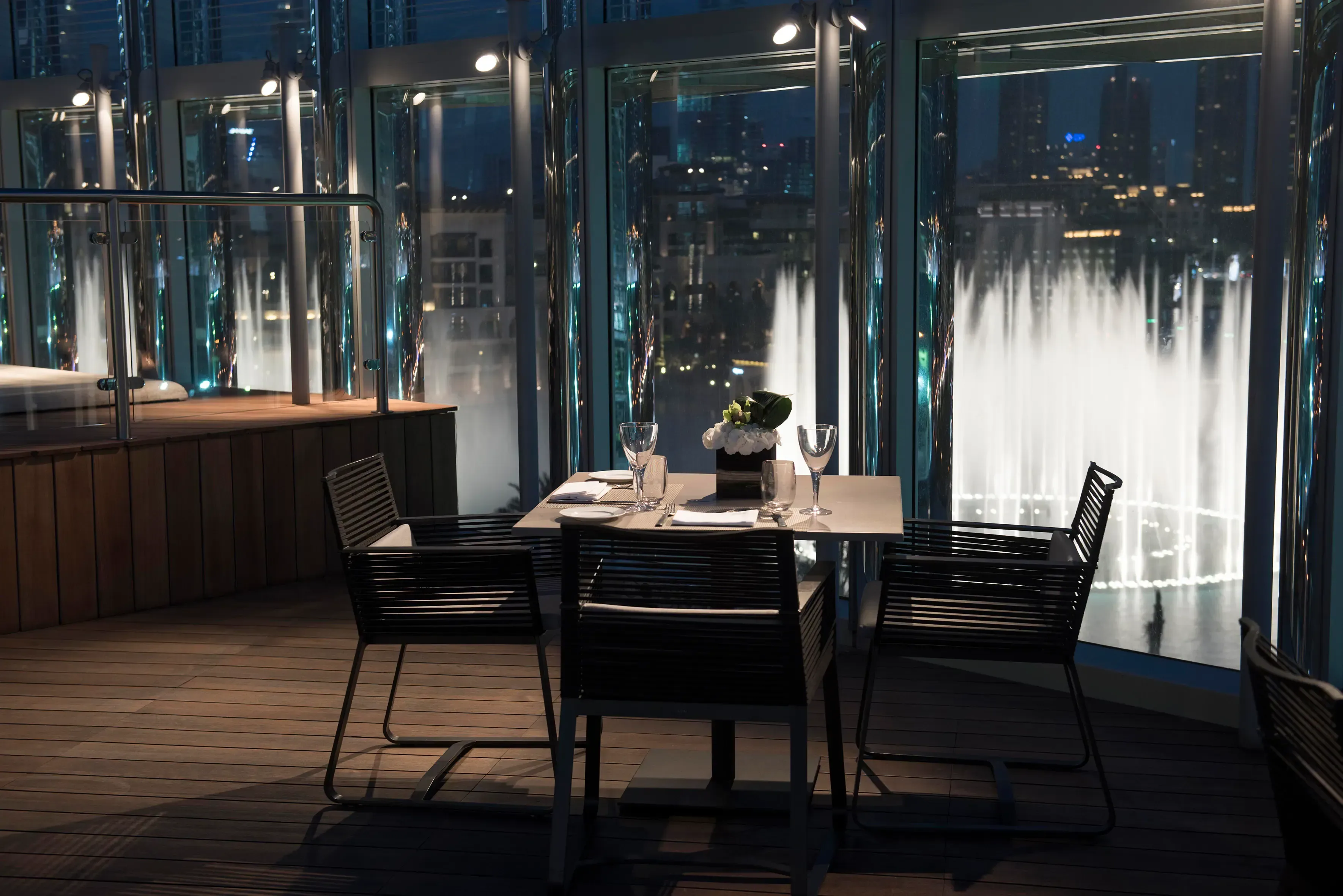 The Rooftop Burj Club dining table overlooking Dubai Fountain at night