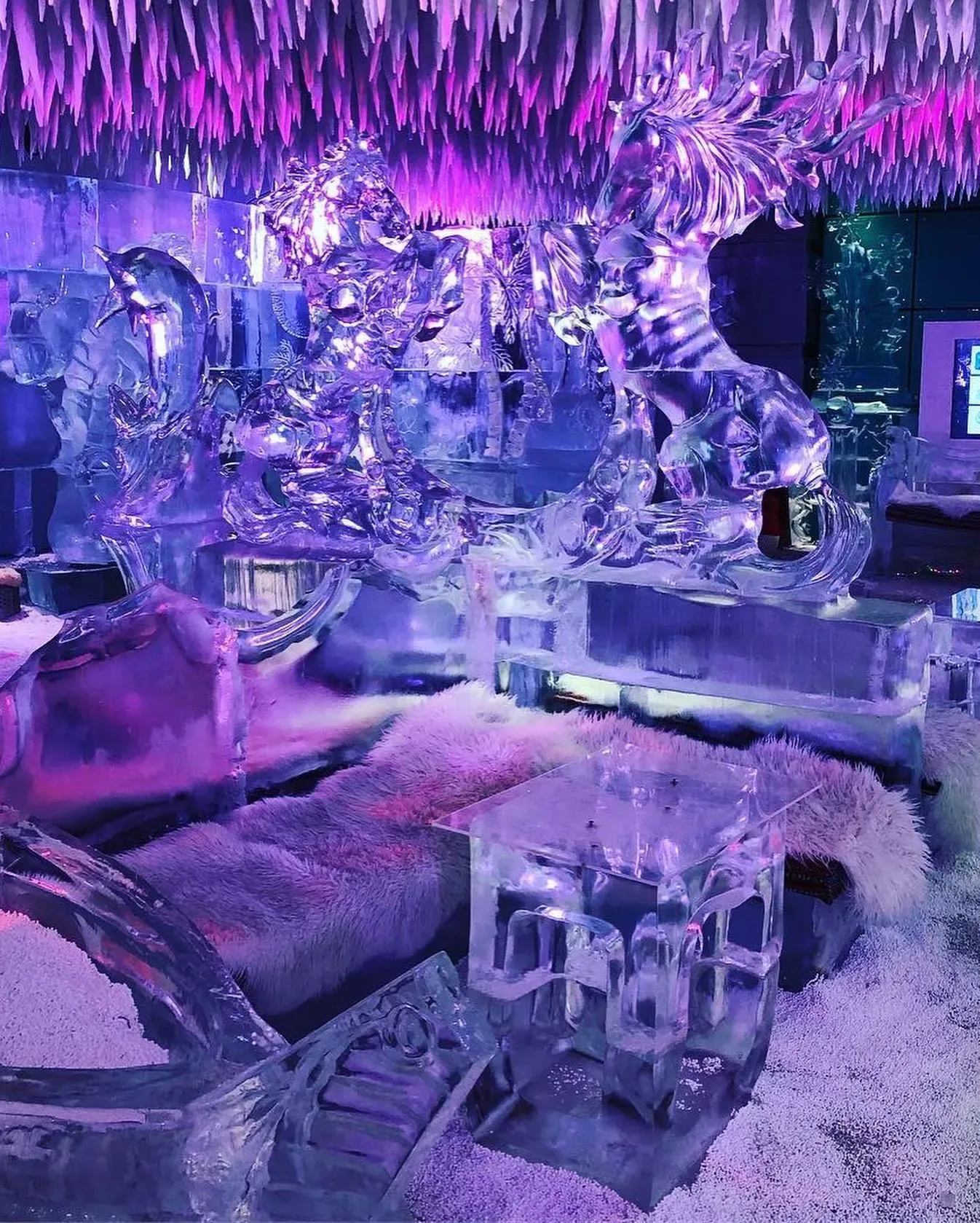 Lion and animal ice sculptures surrounded by blue and purple lights at Chillout Ice Lounge Dubai