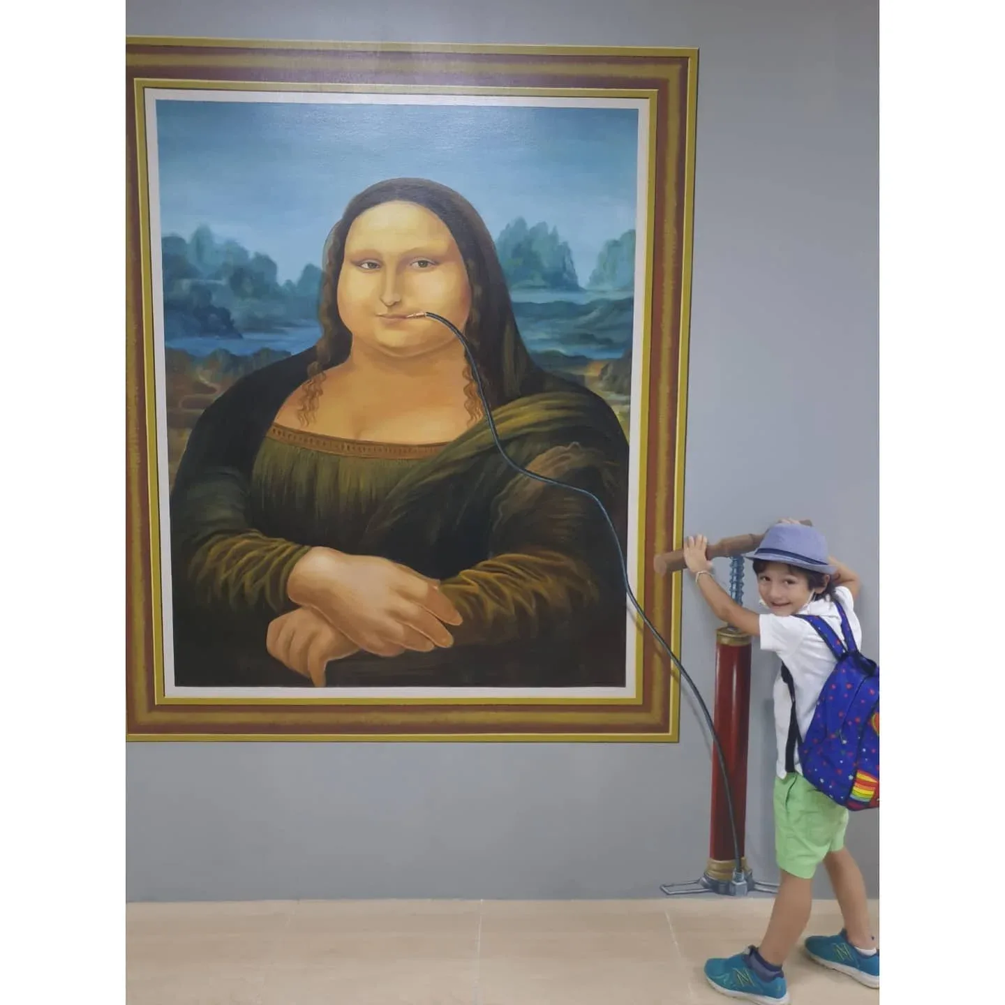 Child posing beside Mona Lisa 3D artwork at 3D World Selfie Museum Dubai