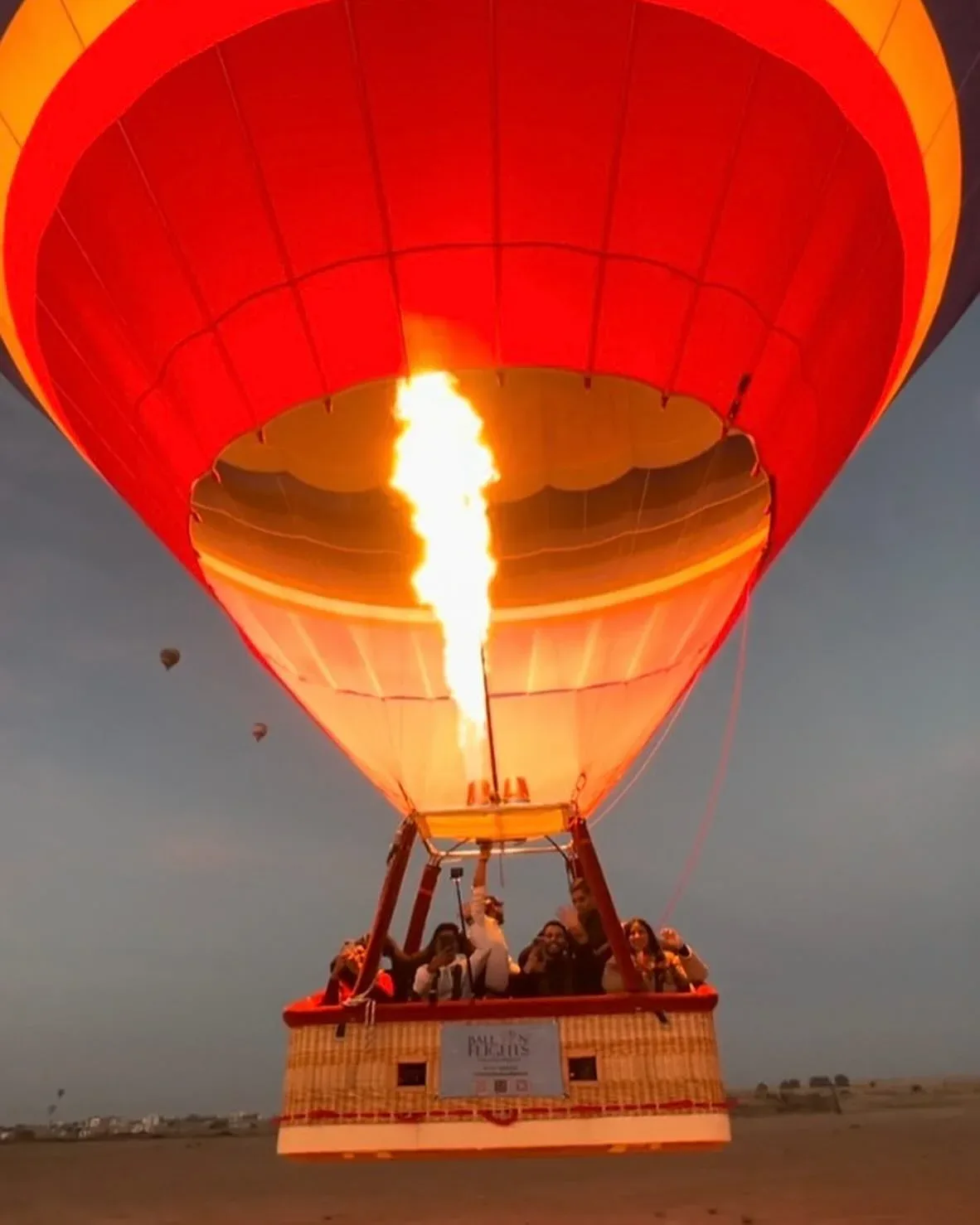Hot air balloon rising over Dubai desert during an early morning flight
