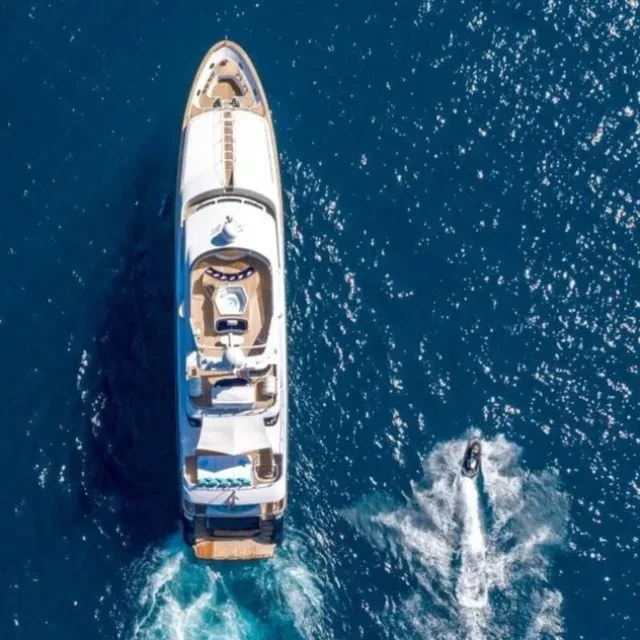 Aerial view of private charter yacht cruising through the blue waters of Dubai