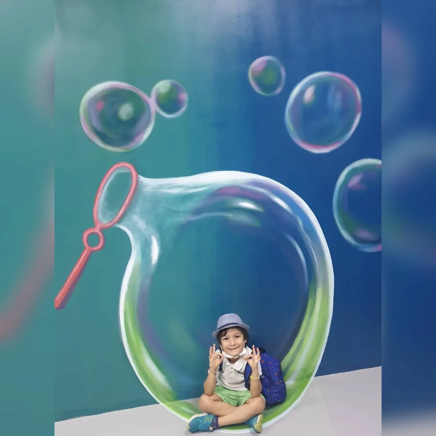 Child sitting inside giant bubble 3D artwork at 3D World Selfie Museum Dubai