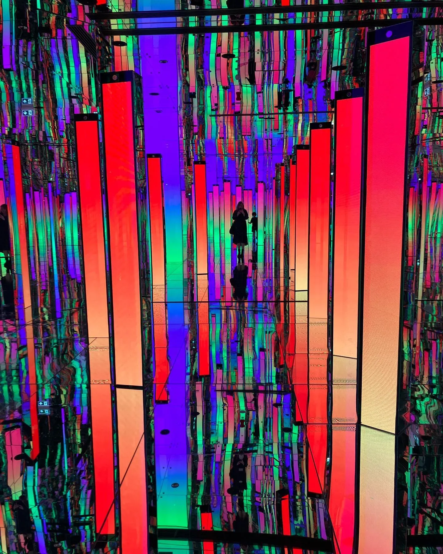 AYA Universe Dubai colorful mirrored room with illuminated red, purple and green vertical light installations