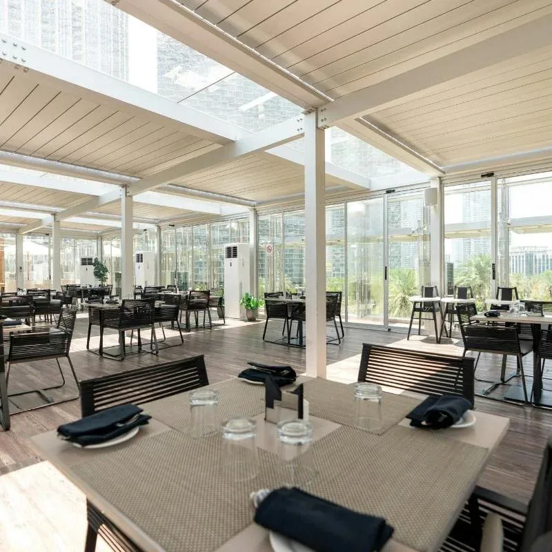 Indoor dining area at The Rooftop Burj Club with modern seating and city views