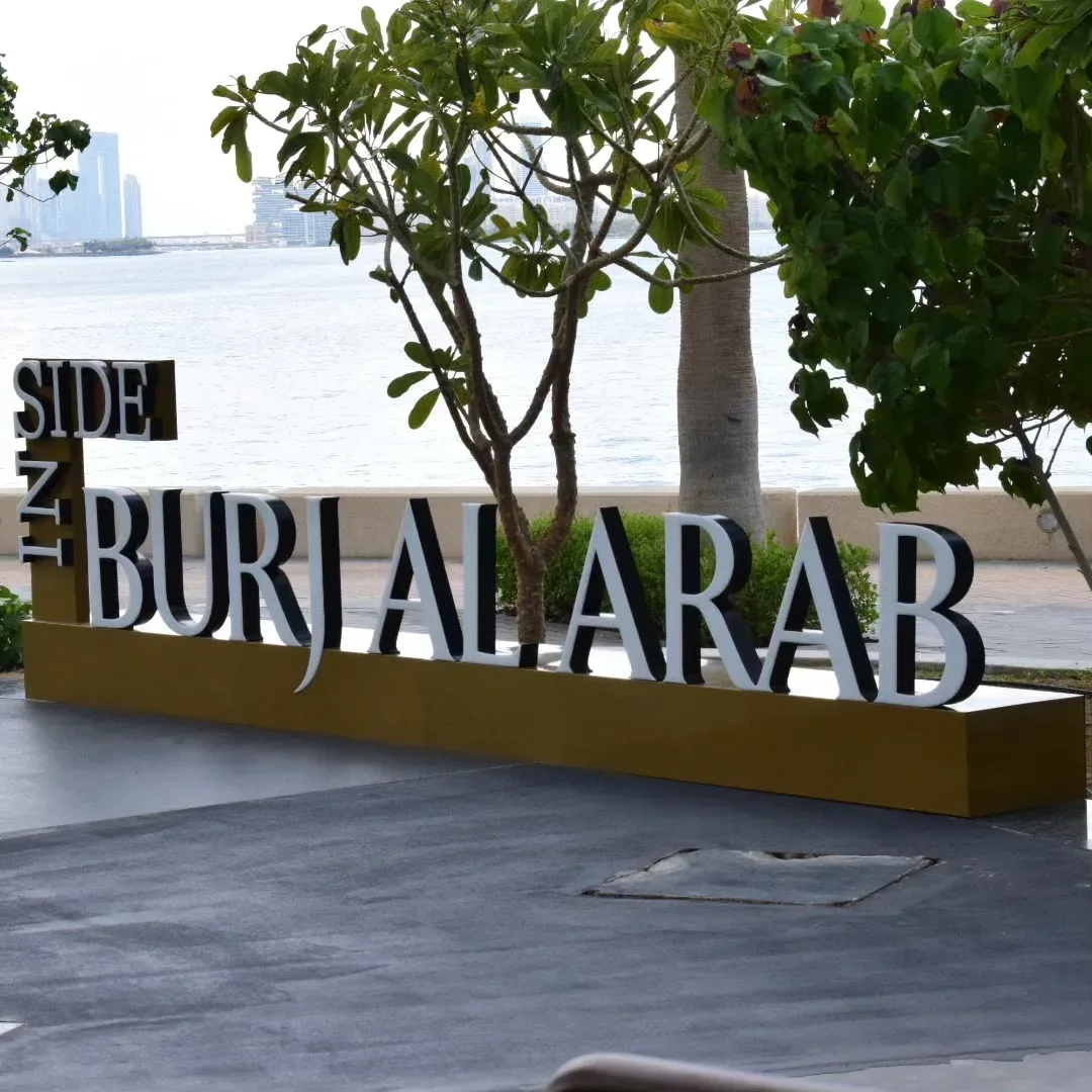 Burj Al Arab sign with Dubai coastline view