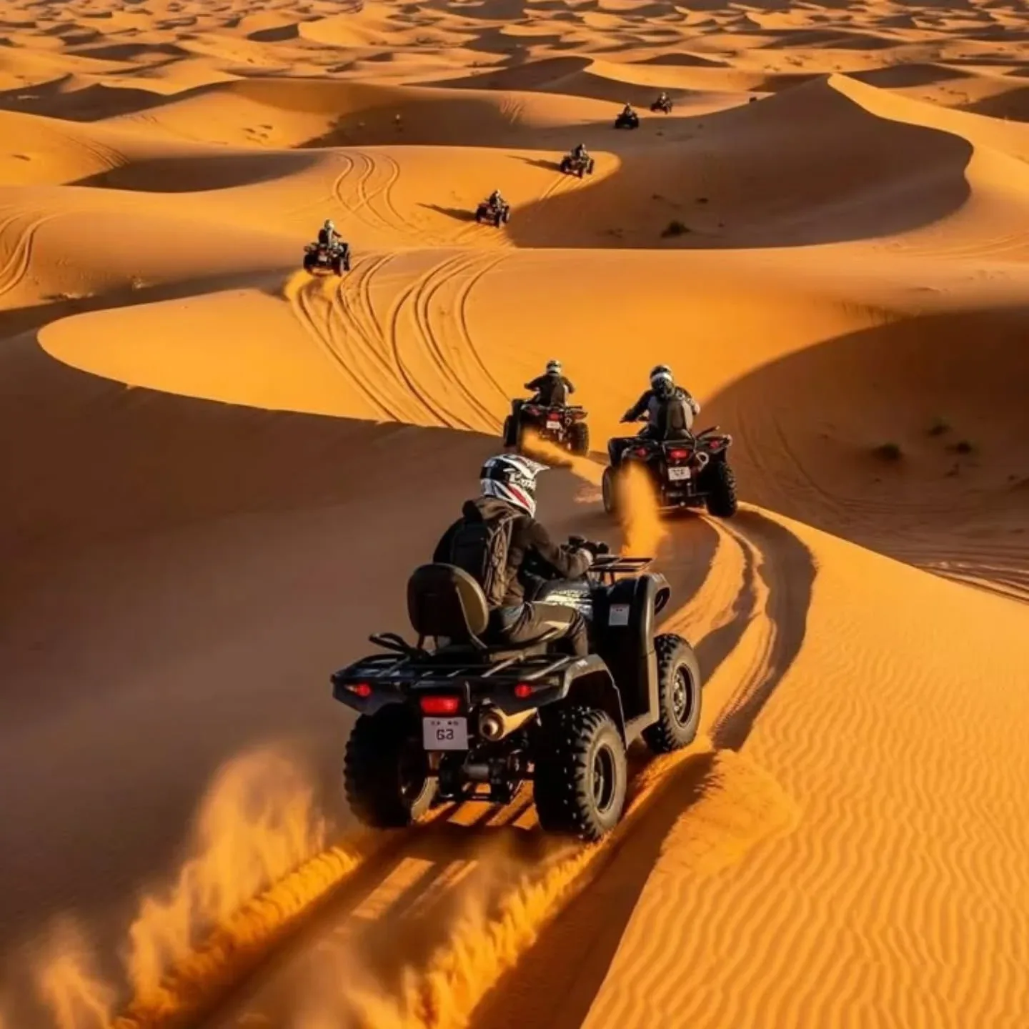 Dubai desert adventure with riders driving quad bikes across golden sand dunes