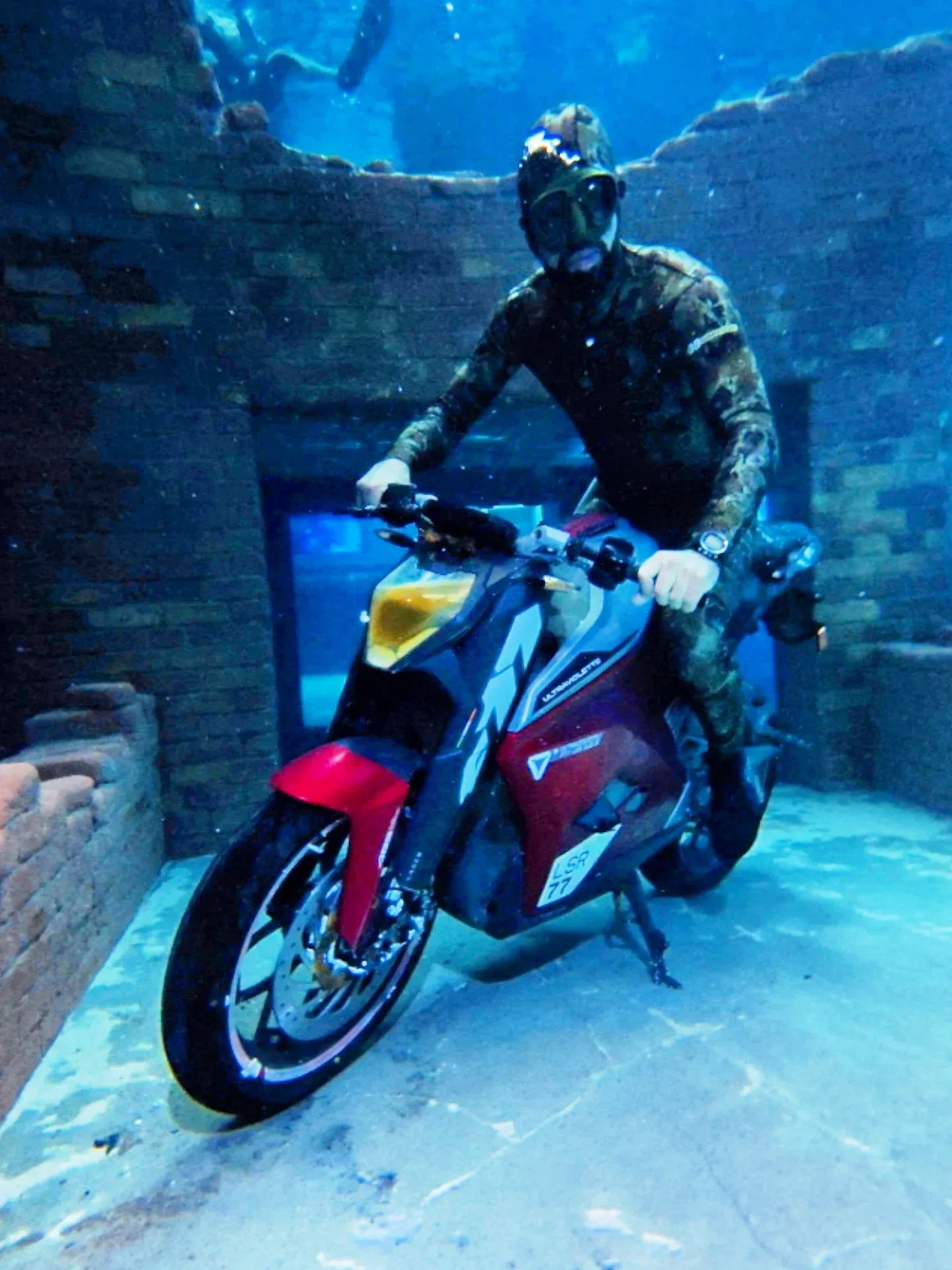 Scuba diver riding a motorcycle at Deep Dive Dubai underwater attraction