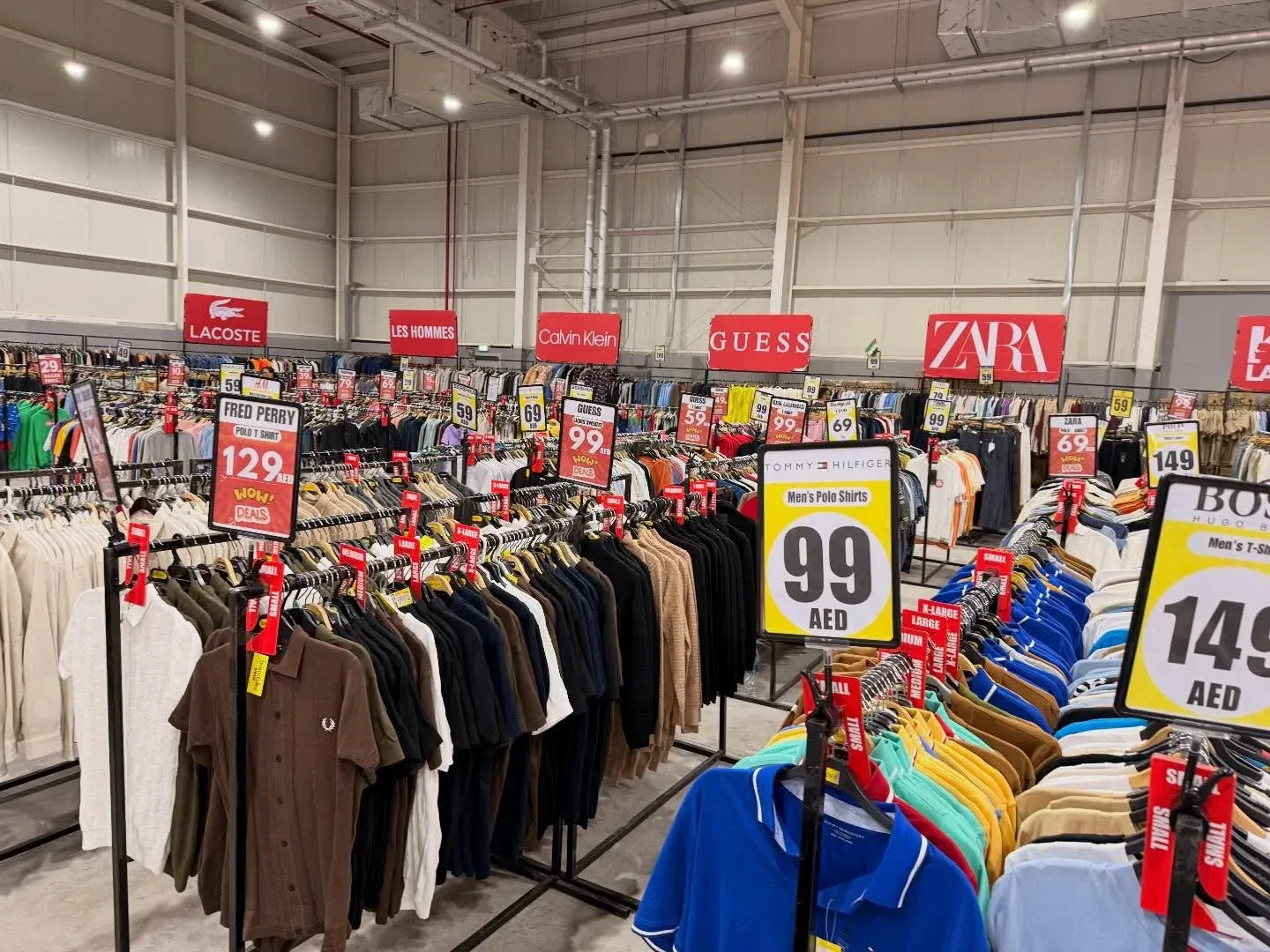 Dubai shopping outlet with clothing racks and branded fashion items on sale